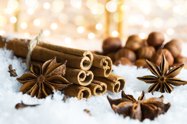 Especias tradicionales de Navidad y nueces en la nieve.