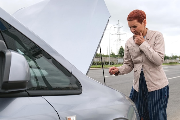 Espeço de mulheres Ela abriu o capô Carro quebrado ao lado Veja os motores danificados ou não