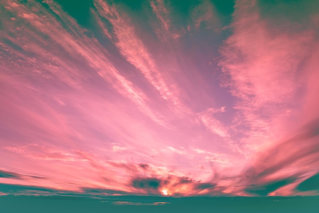 Espectacular cielo nublado colorido al atardecer. Gradiente de color rosa y verde pacífico