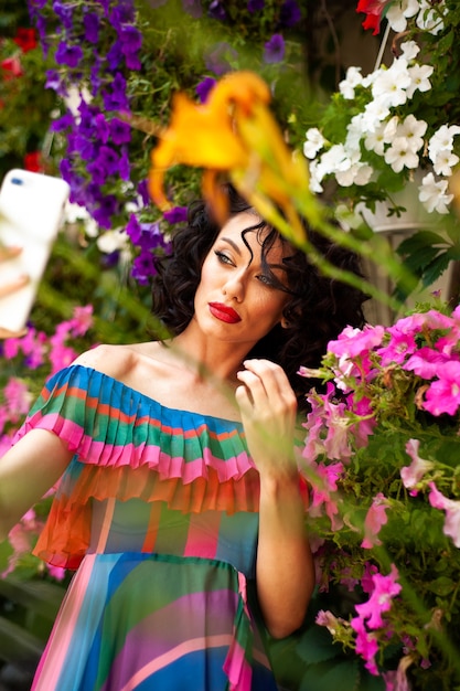 Espectacular mulher europeia bonita e sensual com cabelo escuro e cacheado em um vestido de verão na cidade