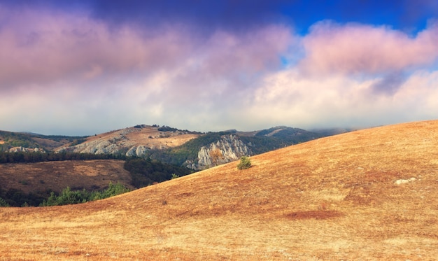 Espectacular paisaje de otoño de montaña al atardecer. Nubes bajas