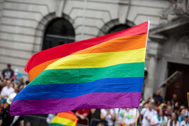 Un espectador ondea una bandera del arco iris gay en una marcha del orgullo gay lgbt en Londres