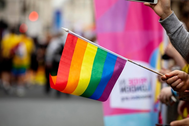 Espectadores agitam uma bandeira de arco-íris gay em um evento da comunidade do orgulho gay lgbt