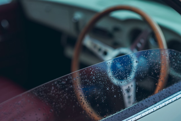 Foto espejo del automóvil junto al conductor que está mojado, lluvioso o tiene gotas de agua sobre el vidrio