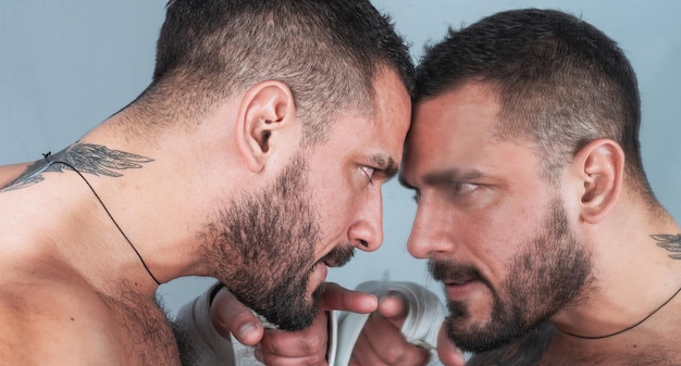 Un espejo donde un hombre se mira a sí mismo Hombre y espejo Hispano barbudo señalando con el dedo al espejo Hombre latino brutal con barba y bigote mirando su reflejo en el espejo