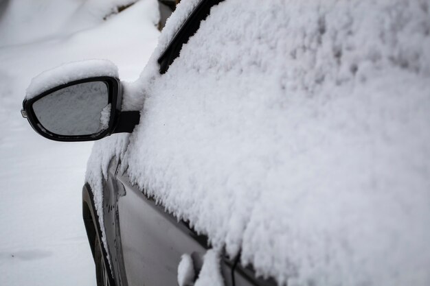 Espejo lateral cubierto de nieve del coche.