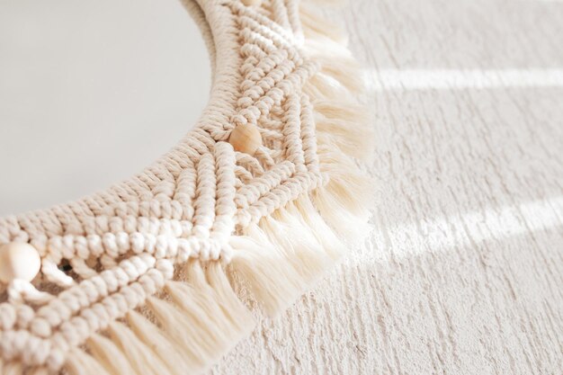 Espejo de macramé en una pared blanca Ecostyle Materiales naturales Fokus suaves Imagen de primer plano Macramé de decoración de cuerda de algodón para hacer que su habitación sea más acogedora y única