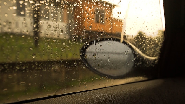 Espejo retrovisor del coche con gotas de lluvia.