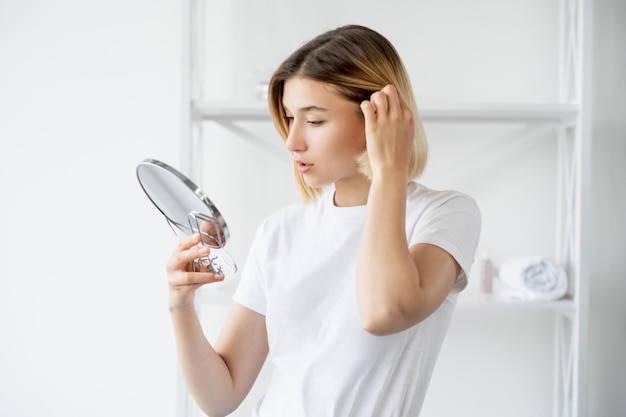 Espelho de mulher de manhã de tratamento de beleza de cuidados com o cabelo