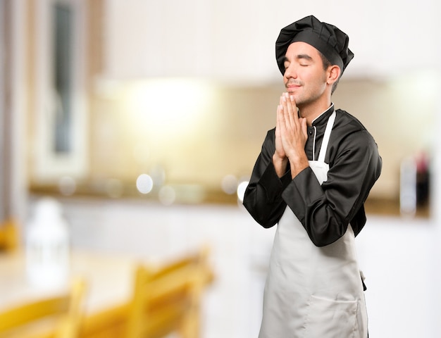 Esperançoso jovem chef praying