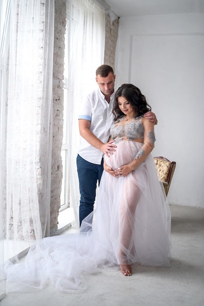 Esperando un bebé. Increíble pareja marido y mujer embarazada posando