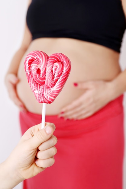 Esperando dulce niña, barriga de mujer embarazada y dulces