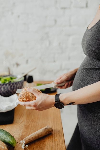 Esperando mamãe fatiando pão na cozinha