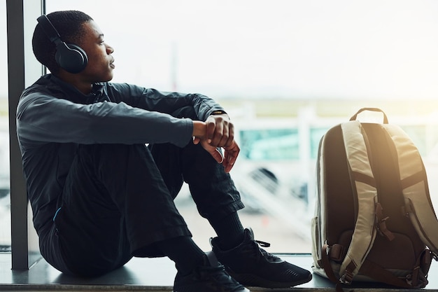 Esperando pacientemente la salida Foto de un joven escuchando música mientras está sentado en el aeropuerto esperando la salida