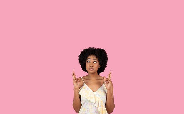 Foto esperanza mujer afroamericana con cabello rizado cruzando los dedos para la buena suerte