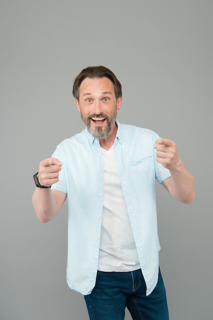 Espere más de su ropa Hombre feliz señalar con los dedos fondo gris Estilo casual