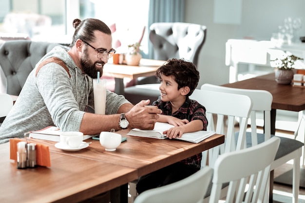 Espere pela pizza. Pai e pai sentados no restaurante esperando pela pizza enquanto passam um tempo juntos no fim de semana