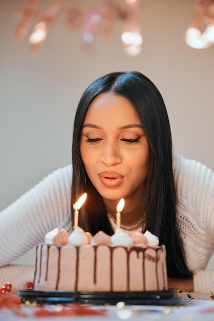 Espero que todos mis deseos se hagan realidad. Foto de una joven que sopla velas en un pastel mientras celebra su cumpleaños en casa.