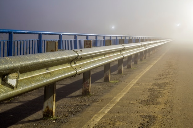 Espesa niebla sobre carretera vacía en la noche