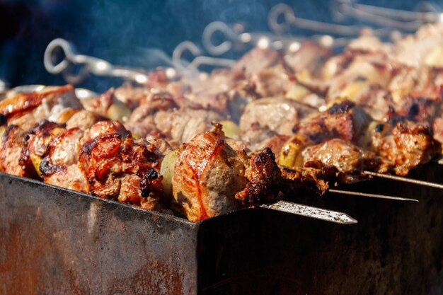 Espetinho grelhado cozinhando no espeto de metal. Carne assada no churrasco. Prato oriental tradicional, churrasquinho. Grelhar no carvão e no fogo, piquenique, comida de rua