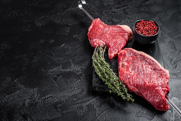 Espeto de churrasco de picanha wagyu envelhecido e seco cru da carne de alcatra com ervas e especiarias Fundo preto Vista superior Espaço para cópia