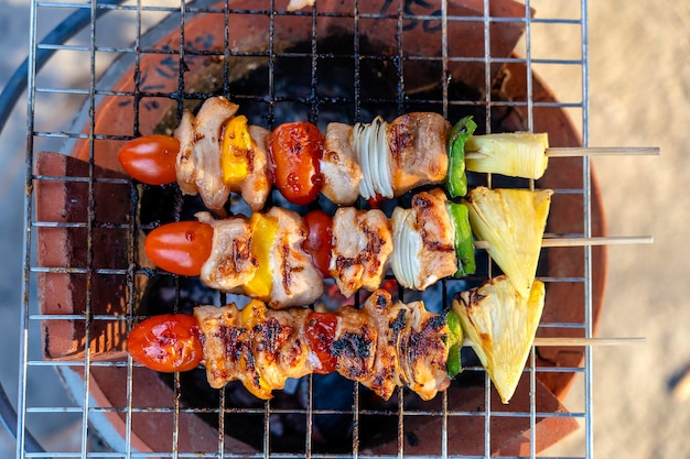 Espetos com pedaços de churrasco grelhado pimentão verde tomate vermelho e carne para venda no mercado de rua Tailândia closeup