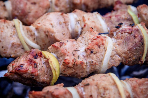 Espetos de carne com cebola no espeto. Carvão vegetal.