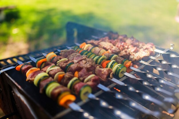 Espetos de carne e vegetais grelhados na natureza