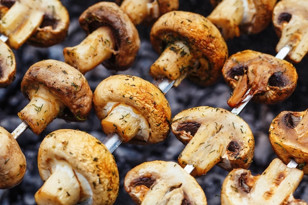 Espetos de churrasco com kebab de cogumelos champignon grelhados em um braseiro