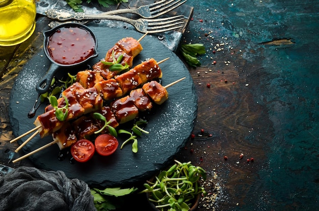 Espetos de frango com molho teriyaki em uma placa de pedra preta estilo rústico menu de churrasco