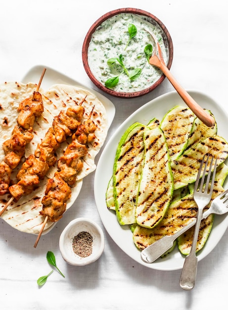 Espetos de frango tortilhas de abobrinha grelhadas e molho tzadziki delicioso almoço estilo grego