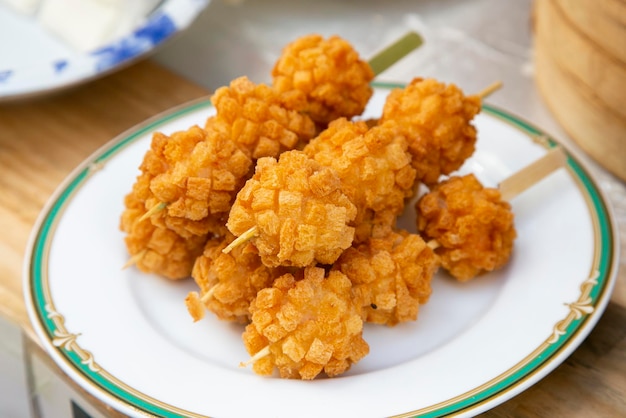 Foto espigas fritas comida de rua chinesa no bairro de nankinmachi, em kobe, japão