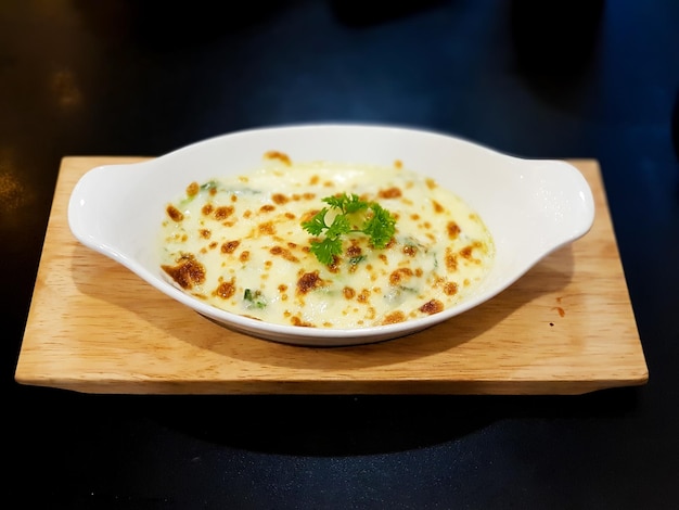 Espinacas al horno con queso sobre fondo de plato blanco