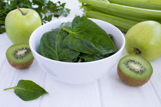 Espinacas en el bol y frutos verdes