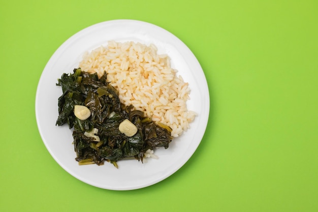 Espinacas fritas con ajo y arroz hervido en un plato