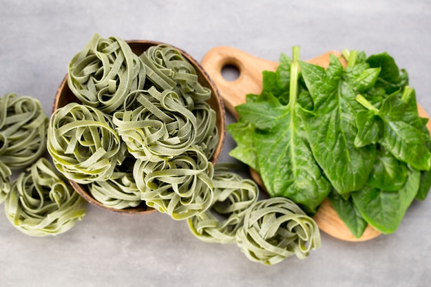 Espinafre fresco com macarrão verde em um cinza