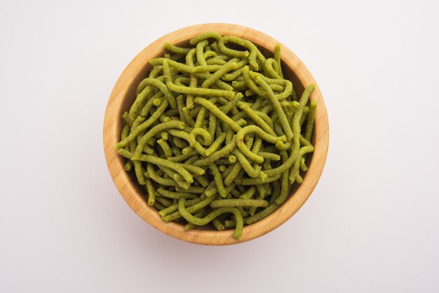 Espinafre ou palak sev são macarrão salgado frito crocante. Caseiro Shev ou namkeen verde espesso e fino é um lanche indiano clássico. servido em uma tigela ou prato