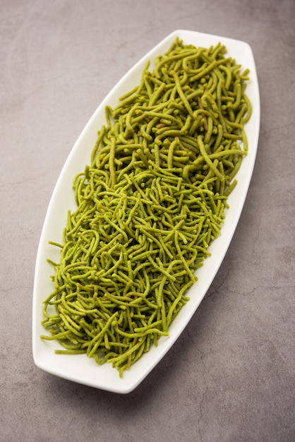 Espinafre ou palak sev são macarrão salgado frito crocante. Caseiro Shev ou namkeen verde espesso e fino é um lanche indiano clássico. servido em uma tigela ou prato