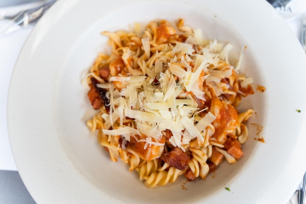 Espirais de macarrão com frutos do mar, carne e queijo ralado em molho de tomate. Prato de comida italiana tradicional