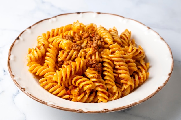 Espiral de pasta fusilli o pasta espiral con salsa de tomate picado estilo comida italiana