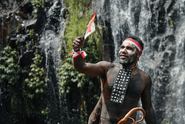 Espírito de Papua homem vestindo roupas tradicionais da tribo Dani redwhite headband e pulseira é segura