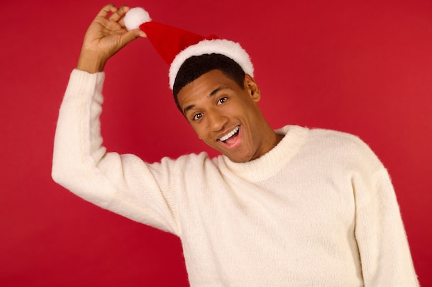 Espirito natalino. Jovem sorridente com um suéter branco e chapéu de Papai Noel