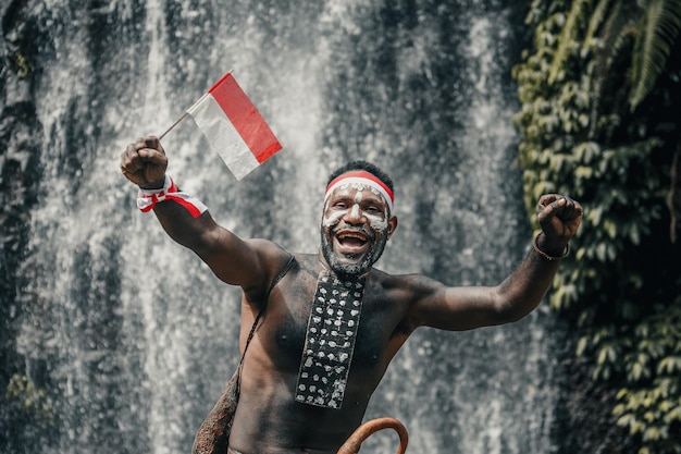 Espírito Papua homem da tribo Dani diz merdeka sorrindo e comemorando o dia da independência da Indonésia novamente