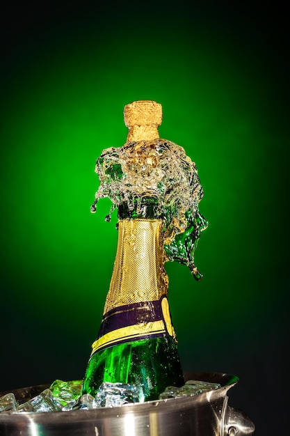 Espirrando champanhe em um fundo verde