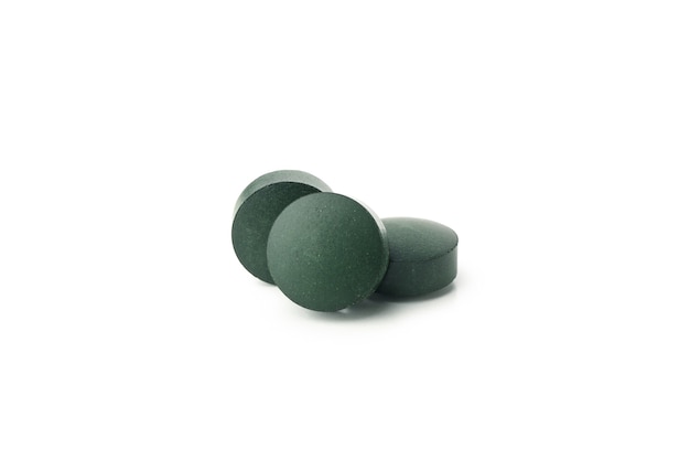 Espirulina en pastillas aislado sobre fondo blanco.