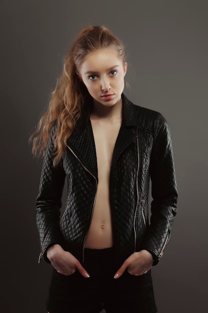 Espléndida joven modelo posando para pruebas de modelo en chaqueta de cuero en el estudio
