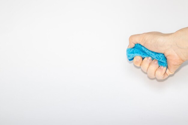 Esponja para cocina y esponjas de colores de mano de mujer sobre fondo gris