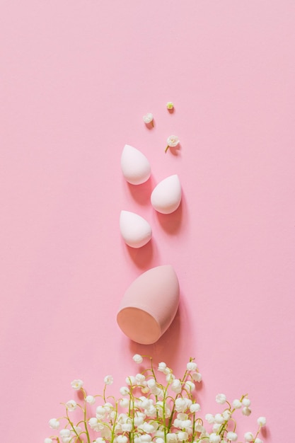 Esponja de maquiagem em um fundo rosa mínimo um conjunto de esponjas de diferentes formas de ovo ferramenta para aplicar creme de base