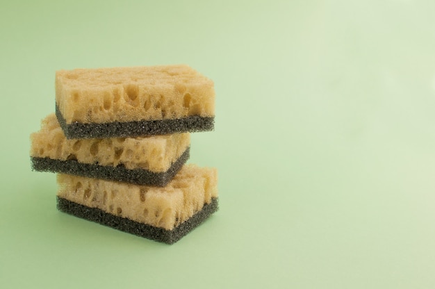 Esponjas para lavar pratos sobre fundo verde