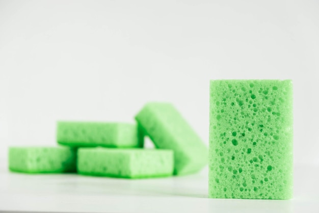 Esponjas verdes para limpar em um fundo branco